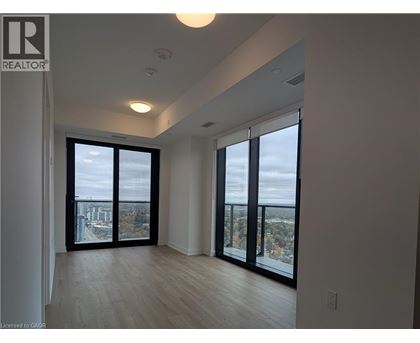 A spacious room with a view of the city through large windows.