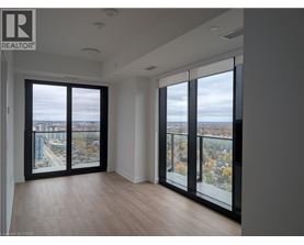A room with a view of the city through large windows.