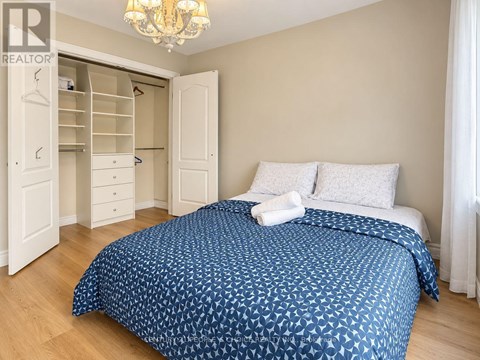 A bedroom with a large bed and a chandelier.