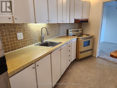 A kitchen with white cabinets and a beige countertop.