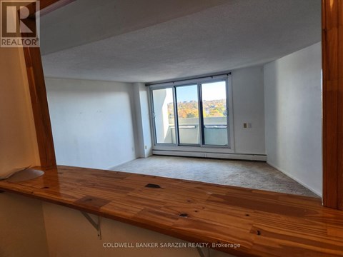 A room with a wooden floor and a sliding glass door leading to a balcony.