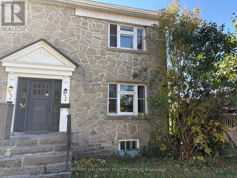 A stone house with a brown door and windows.