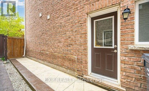 A red brick house with a brown door and a small window above it.