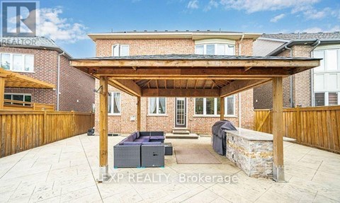 A covered patio area with a couch and a table.