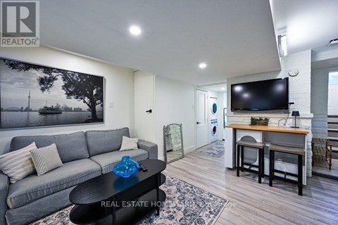 A living room with a grey couch and a coffee table in front of a large painting.