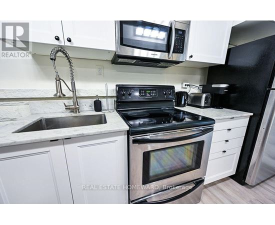A modern kitchen with white cabinets and stainless steel appliances.