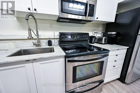 A modern kitchen with white cabinets and stainless steel appliances.