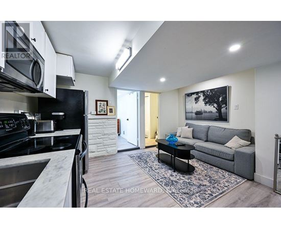 A modern kitchen with a stainless steel stove and a black fridge.