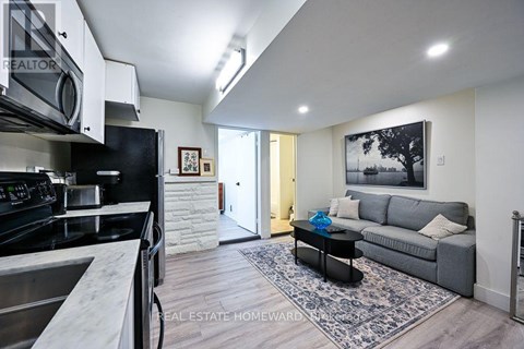 A modern kitchen with a stainless steel stove and a black fridge.