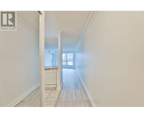 A hallway with a doorway leading to a room with a window.