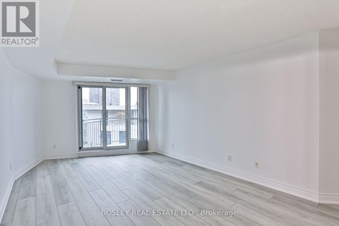 A spacious room with a sliding glass door leading to a balcony.