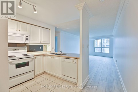 A kitchen with white appliances and cabinets is on the market with Bosley Real Estate LTD.