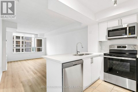 A white kitchen with a sink and stove.