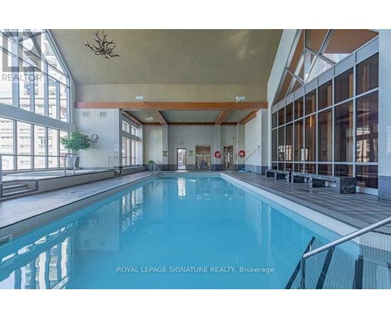 A large indoor swimming pool with a glass wall on one side.