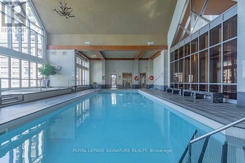 A large indoor swimming pool with a glass wall on one side.