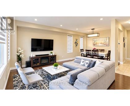A living room with a grey sofa, a white coffee table, and a television on the wall.