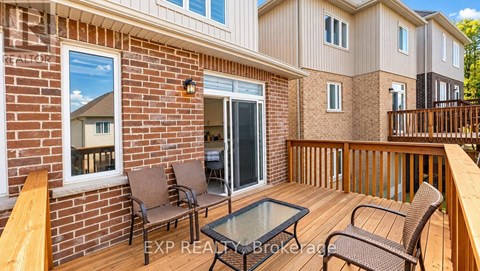 A balcony with a glass table and chairs overlooking a brick building.