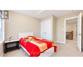 A bedroom with a bed covered in a red and gold comforter.