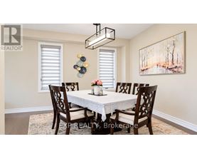 A dining room with a white table and chairs.