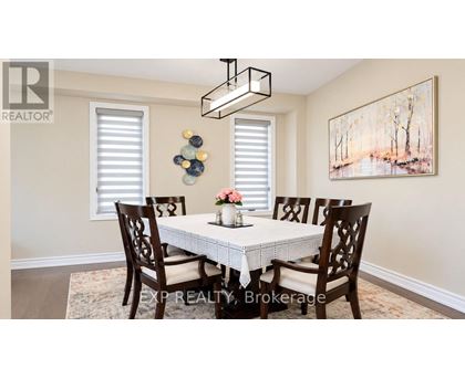 A dining room with a white table and chairs.