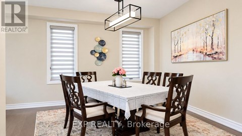 A dining room with a white table and chairs.