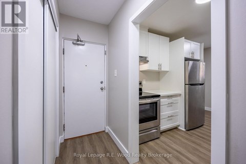 A small kitchen with a refrigerator, oven, and microwave.