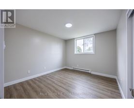 A room with a window and wooden flooring.