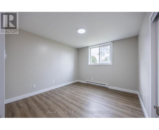A room with a window and wooden flooring.
