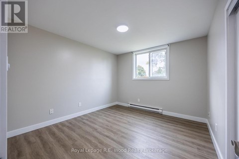 A room with a window and wooden flooring.
