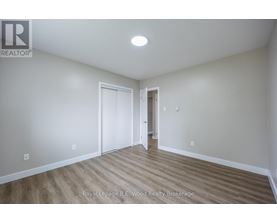 A room with wood flooring and white walls.