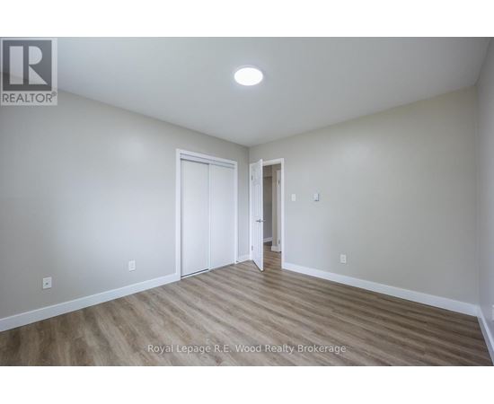 A room with wood flooring and white walls.