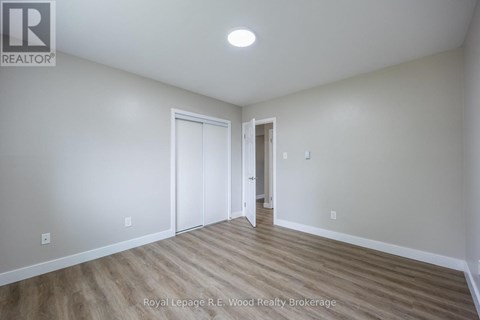 A room with wood flooring and white walls.