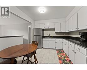 A kitchen with white cabinets and a wooden table.