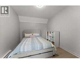 A bedroom with a bed and a nightstand.