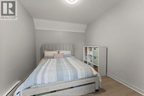 A bedroom with a bed and a nightstand.