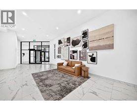 A living room with a couch, a rug, and pictures on the wall.