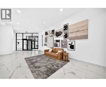 A living room with a couch, a rug, and pictures on the wall.