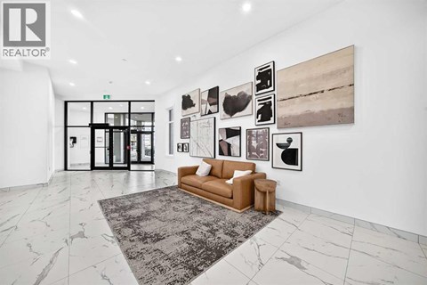 A living room with a couch, a rug, and pictures on the wall.