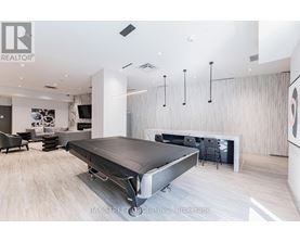 A modern bedroom with a bed in the center and a desk to the right.