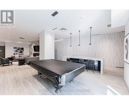A modern bedroom with a bed in the center and a desk to the right.