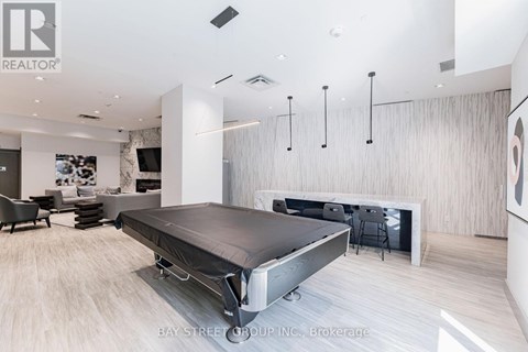 A modern bedroom with a bed in the center and a desk to the right.