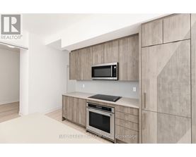A modern kitchen with a microwave and oven built into the cabinetry.