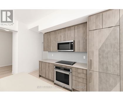 A modern kitchen with a microwave and oven built into the cabinetry.