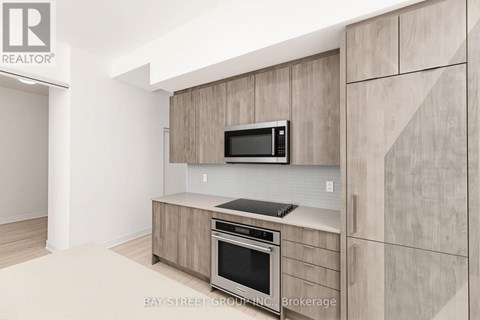 A modern kitchen with a microwave and oven built into the cabinetry.