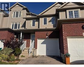 A house with a white garage door and a brick wall.
