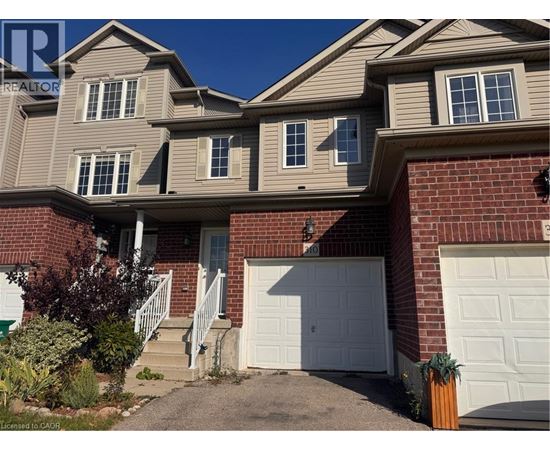 A house with a white garage door and a brick wall.