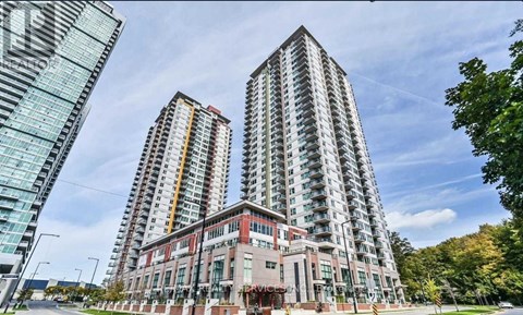 Two tall buildings with balconies are in the foreground with a building in the middle.