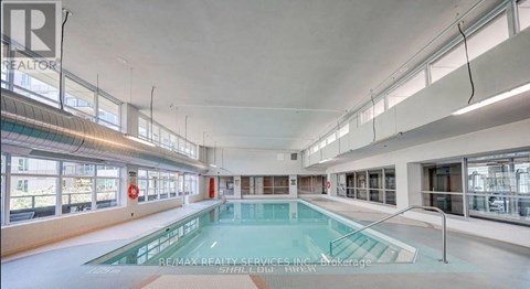 A large indoor swimming pool with a glass divider.