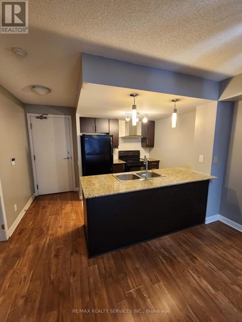 A kitchen with a sink and a refrigerator.