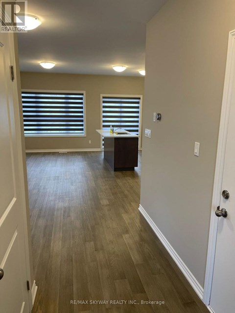 A hallway with wood flooring and white walls.
